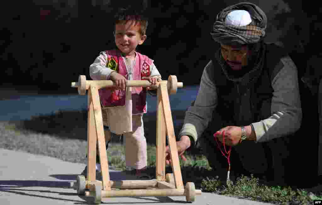 A 3-year-old child patient who lost his leg in a suicide attack in Kandahar walks with the aid of a stroller at the International Red Cross Center in Kabul. (AFP/Jawad Jalali)