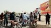 Afghan security officials check people on a roadside in Helmand as security has been intensified ahead of the upcoming parliamentary elections.