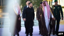 Na fotografiji koju je snimila i objavila pres-služba ukrajinskog predsednika 10. marta 2025, Volodimira Zelenskog po dolasku dočekuje saudijski zamenik guvernera Meke, princ Badr bin Sultan bin Abdulaziz