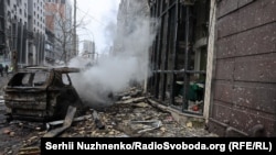 Smoke billows from a burned-out car following Russian missile strikes on Kyiv on December 20. 