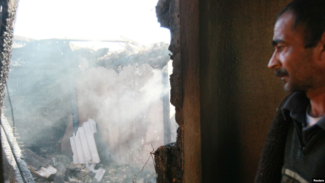 A man stands in the burned ruins of his house in Maevka on April 20.