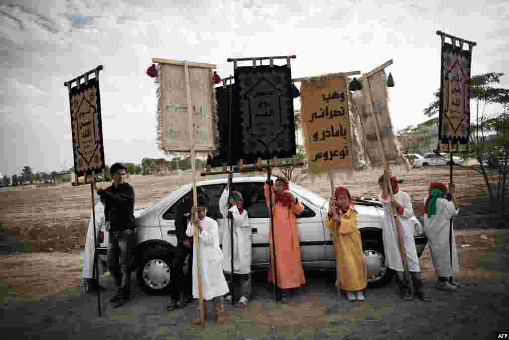 Children hold banners during a Ta&#39;zieh performance.