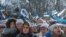 People wave national flags in front of the Estonian parliament during a festive ceremony to celebrate 100 years since the Baltic state declared independence for the first time in 1918. 