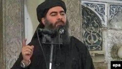 На кадре пропагандистского видеообращения ИГ предположительно Абу Бакр аль-Багдади, известный как лидер ИГ и халиф самопровозглашенного исламского халифата.