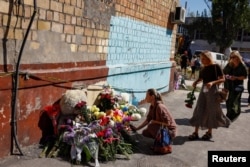  Жена слага цветя на спонтанен мемориал в памет на жертвите на съветската офанзива над Киев, 29 август 2025 година 