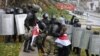 Riot police detain protesters carrying the red-and-white flag of the Belarusian opposition on November 8 in Minsk.