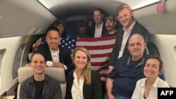 Na fotografiji koju je objavila američka vlada: novinar Wall Street Journala Evan Gershkovich (lijevo), bivši američki marinac Paul Whelan (drugi s desna) i novinarka RSE/RL Alsu Kurmasheva (desno)u avionu nakon što su pušteni iz Rusije 1. avgusta.