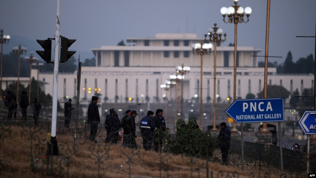 Police officers gather at a secured street leading to the Presidential Palace and Parliament House in Islamabad on January 11.
