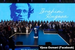 Vjosa Osmani, gjatë fjalimit në eventin hapës të fushatës zgjedhore për LDK-në. Në prapavijë, një foto dhe emri i Ibrahim Rugovës.