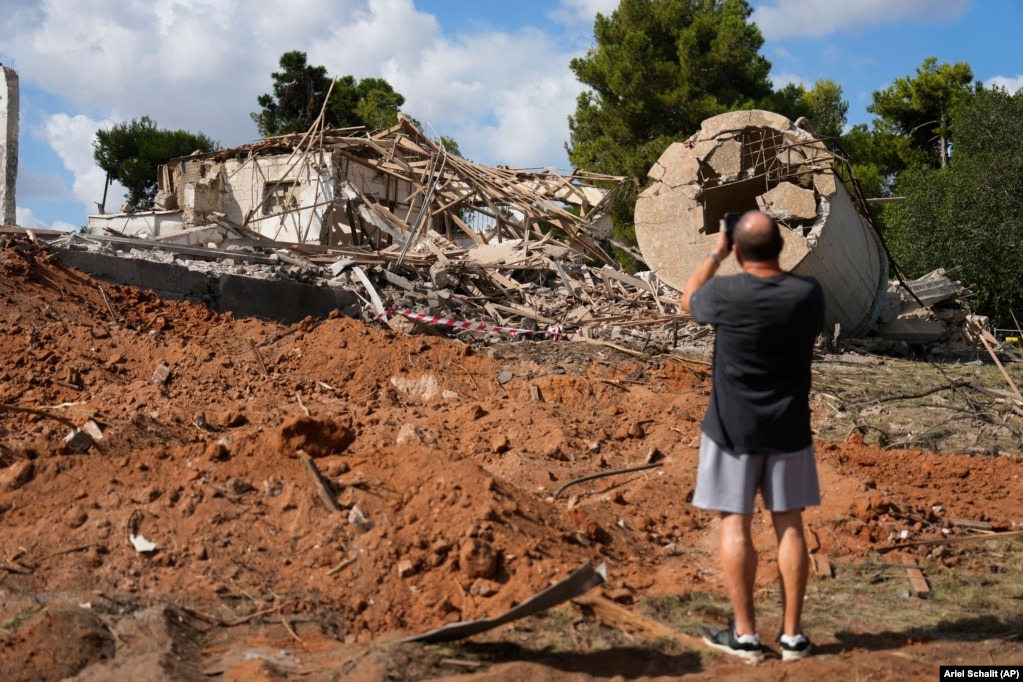 Një burrë fotografon një ndërtesë në Hod HaSharon, afër Tel Avivit, e cila u shkatërrua në sulmin e 1 tetorit.