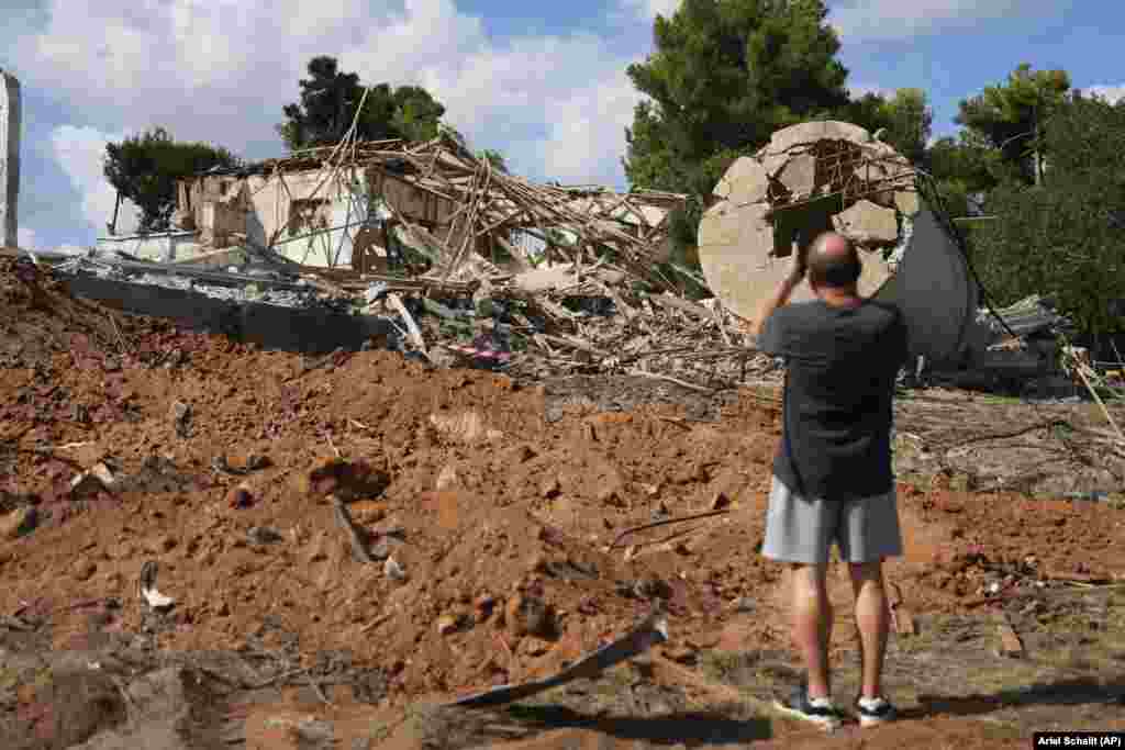 Un bărbat fotografiază o clădire din Hod HaSharon, lângă Tel Aviv, care a fost distrusă în atacul de la 1 octombrie.