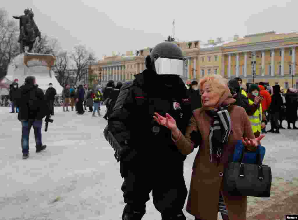 Полицейлер Алексей Навальныйды босатуды талап етіп алаңға шыққан әйелді ұстап әкетіп барады. Санкт-Петербург, Ресей. 23 қаңтар, 2021 жыл.&nbsp;