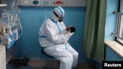 Иллюстрациялык сүрөт. Кытай. Медайым коронавирус жуккан ымыркай менен отурат. 16-март, 2020-жыл.