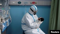 Иллюстрациялык сүрөт. Кытай. Медайым коронавирус жуккан ымыркай менен отурат. 16-март, 2020-жыл.
