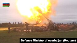 В кадре из видео, опубликованного Министерством обороны Азербайджана, видно как военнослужащие азербайджанских вооруженных сил ведут артиллерийский огонь.