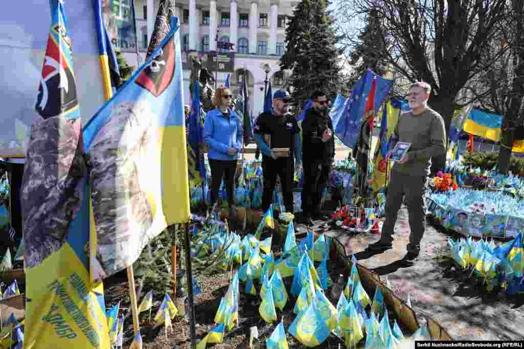 American businessman and volunteer Bill Cole holds a portrait of Ian Frank Tortorici during a ceremony to commemorate six fallen US fighters on Kyiv's Independence Square on March 14.