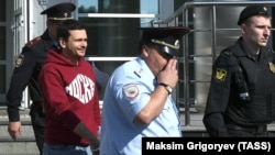 Russian opposition figure and disqualified election candidate Ilya Yashin (left) is escorted to a court in Moscow on July 29. 