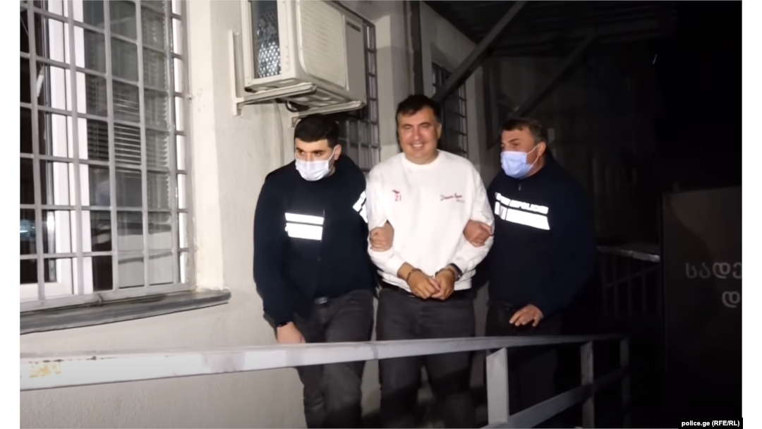 Georgian ex-President Mikheil Saakashvili is escorted by police officers as he arrives at a prison in Rustavi on October 1.