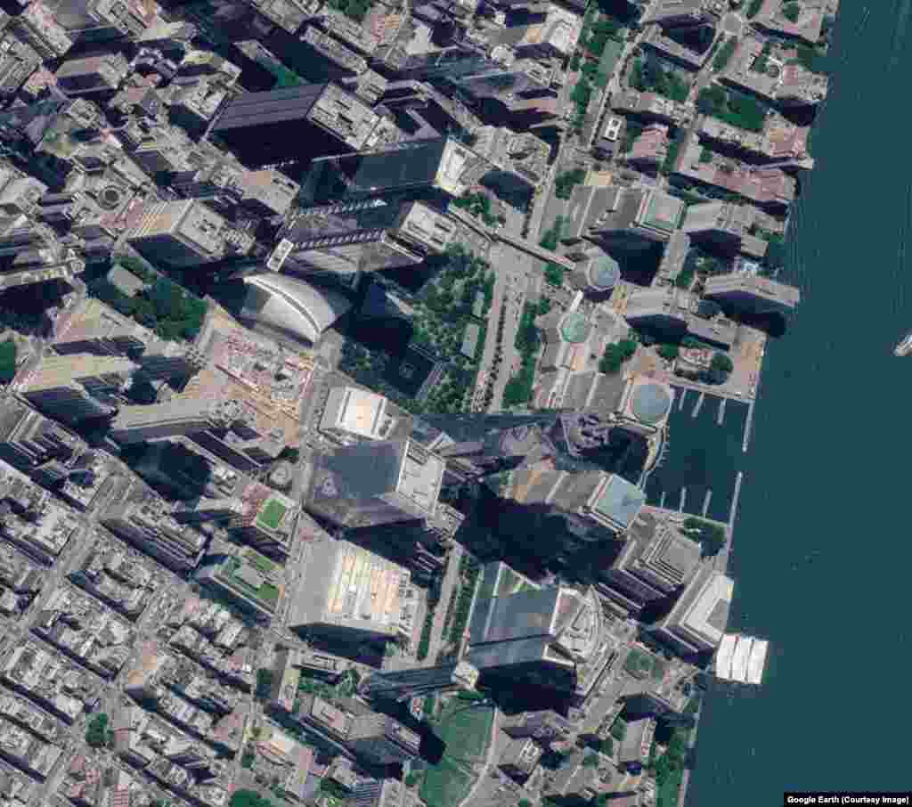 Lokacija Svjetskog trgovinskog centra u Njujorku, viđeno 15. septembra 2001. godine, dok se dim diže od napada 11. septembra.Slika obnovljene lokacije iz 2026. godine snimljena je 25. juna.