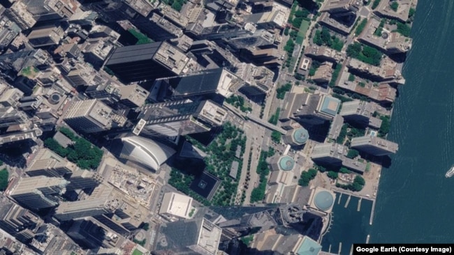 The site of the World Trade Center in New York City seen on September 15, 2001, as smoke rises from the September 11 attacks.The 2026 image of the rebuilt site was captured on June 25.