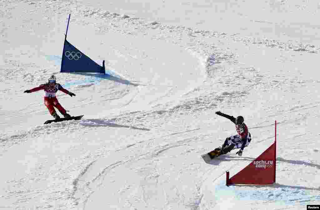 Switzerland&#39;s Nevin Galmarini (left) and Russia&#39;s Vic Wild compete during the men&#39;s snowboard parallel giant slalom finals. Wild won the gold medal. (Reuters/Dylan Martinez)