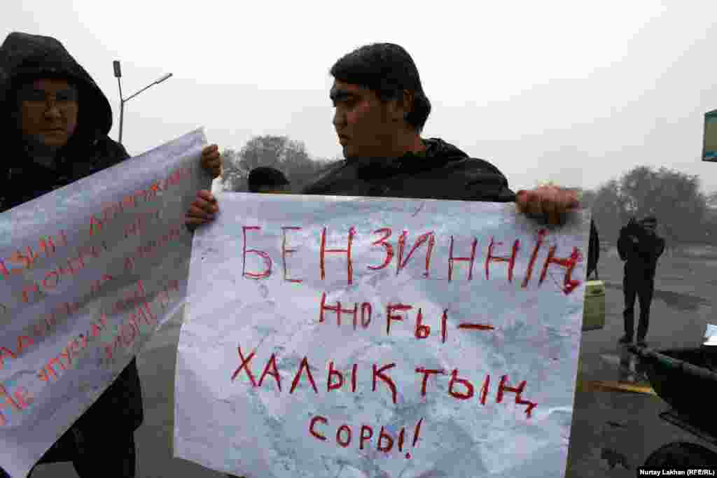 Участники акции держали в руках плакаты на казахском и русском языках. На этом плакате на казахском написано: &laquo;Бензина нет &ndash; это горе народа&raquo;. 