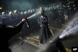 Riot police use pepper spray to clear a protester during a demonstration in Istanbul on March 23 after the city's mayor, Ekrem Imamoglu, was arrested and jailed.