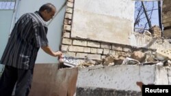 An ethnic Uzbek man in the yard of his house, burned out during the ethnic clashes in Osh in June.