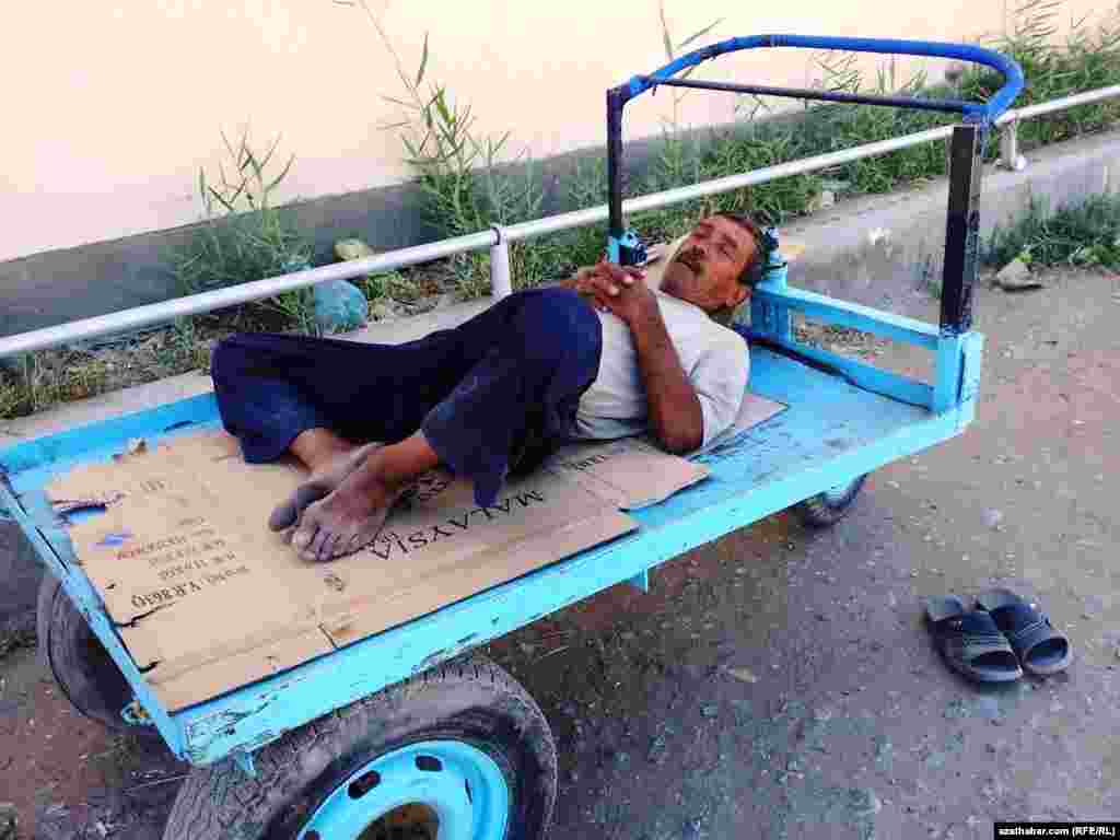 Arabanyň üstünde dynç alyp ýatan bir adam