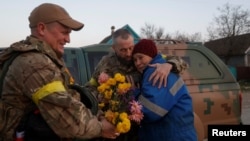 Local resident Valentyna Buhaiova embraces Ukrainian soldiers in the recently retaken village of Kyselivka, outside of Kherson, on November 12.