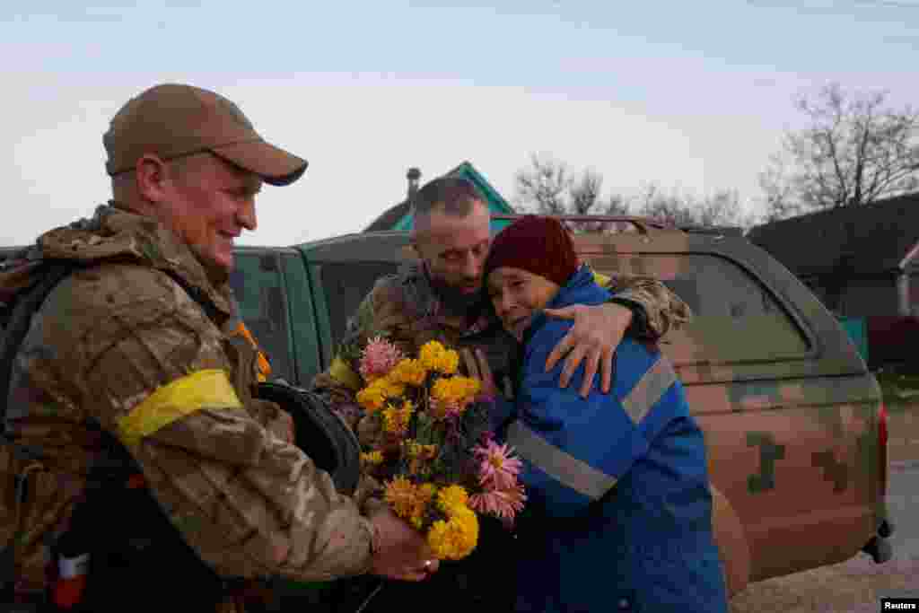 Local resident Valentyna Buhaiova embraces Ukrainian soldiers in the recently retaken village of Kyselivka, outside of Kherson on November 12.