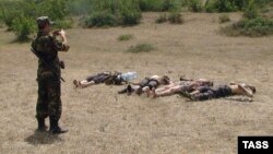 A Russian soldier photographs the bodies of four alleged militants killed in clashes in Daghestan. (file photo)