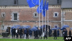 Liderii europeni, cu umbrele, se adună pentru o „fotografie de familie” la reuniunea informală de la Castelul Alden Biesen, în centrul Belgiei, pe 12 februarie 2026. 