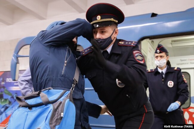 Një zyrtar policor rus teksa arreston një person në një stacion metroje në Novosibirsk më 23 tetor. (TASS/Kirill Kukhman)