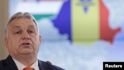 Orbán Viktor egy Romániát és Magyarországot ábrázoló térkép előtt Bukarestben 2022. december 17-én