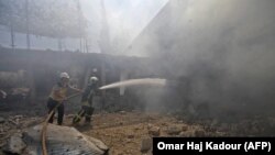 Сирійські пожежники борються з вогнем у приміщенні після бомбардування російської авіації
