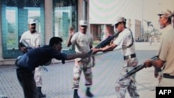 The Awaz News TV channel image from June 10, 2011, shows paramilitary soldiers shooting unarmed Pakistani youth Sarfaraz Shah (left) in Karachi on June 8.