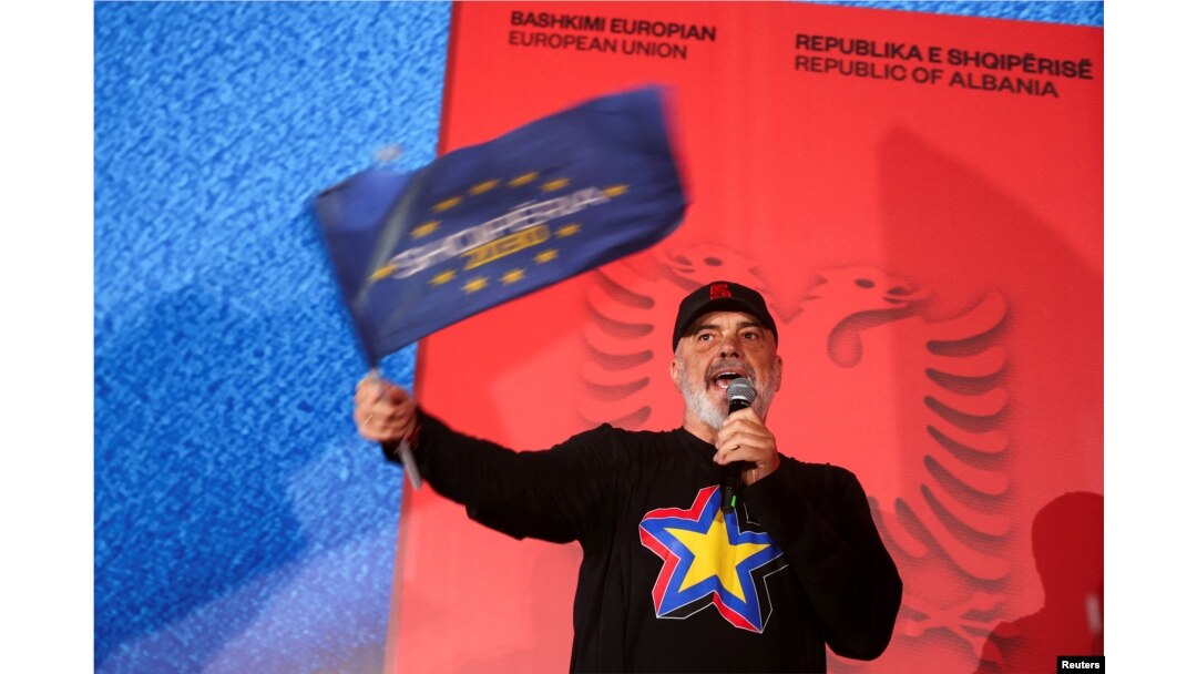Liderul Partidului Socialist și prim-ministru al Albaniei, Edi Rama, flutură un steag în timp ce își ține discursul de la mitingul electoral de la Fier, Albania, pe 7 mai 2025.