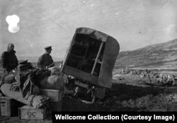 ფოტოზე ასახულია პირველი მსოფლიო ომის დროინდელი სამეფო საზღვაო ძალების ჯავშანტექნიკის სასწრაფო დახმარების გაფუჭებული მანქანა სარეგისტრაციო ნომრით - „OA8890“. გვერდით ორი მამაკაცი დგას. მოჩანს დაჭრილებისთვის განკუთვნილი საკაცეები და მანქანიდან გადმოტანილი ნივთები.