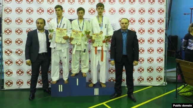 Илья Грейнер (в центре) на школьных соревнованиях по самбо