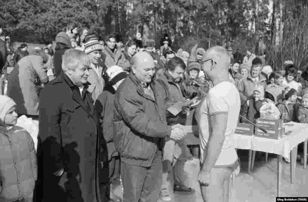 Yury Luzhkov (center), then chairman of the Executive Committee of the Moscow Council, congratulates a veteran of the Serebryany Bor winter swimming club on March 8, 1991.&nbsp;