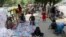 Afghan people rest on tents and blankets as they seek to receive asylum from the United Nations High Commissioner for Refugees in Islamabad on May 9, 2022. 