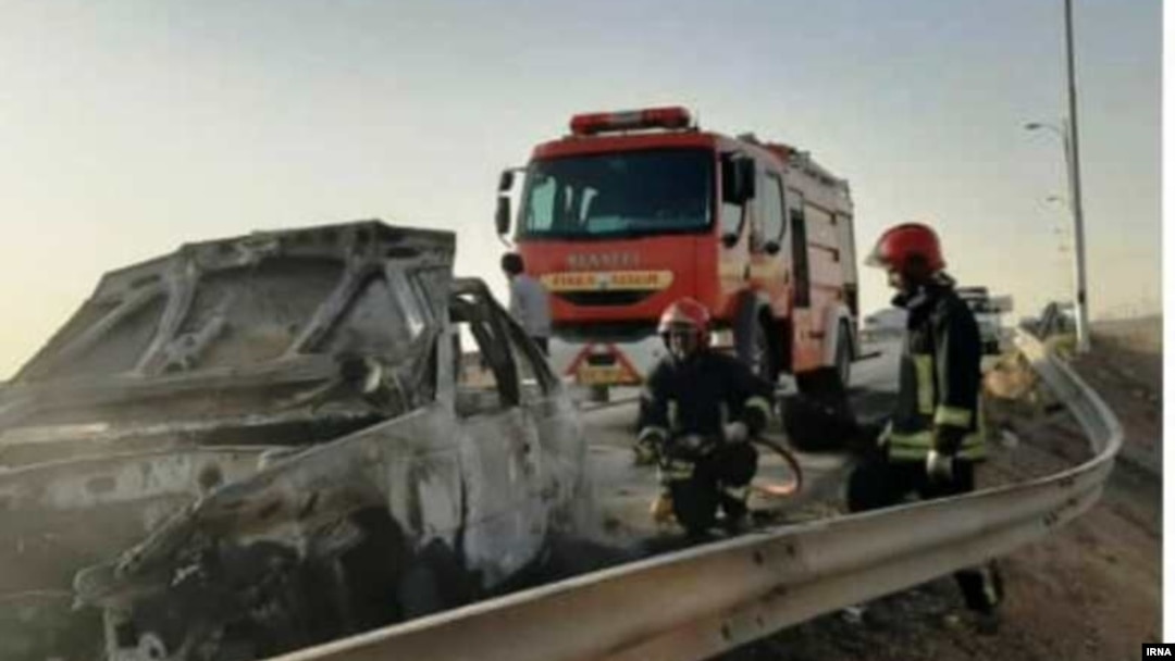 Emergency workers remove a car which exploded into flames after Iranian police reportedly opened fire on it. Three Afghan migrants died in the incident. 
