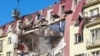 Ukrainian rescuers work at the site of an apartment building hit by a Russian drone strike in Odesa on April 6