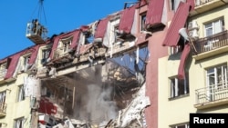Ukrainian rescuers work at the site of an apartment building hit by a Russian drone strike in Odesa on April 6