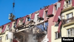 Ukrajinski spasioci na stambenoj zgradi koja je pogođena ruskim dronom, Odesa, 6. april 2026.