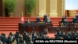 North Korean leader Kim Jong Un and attendees applaud at the second-day sitting of the 5th Session of the 14th Supreme People's Assembly (SPA) of the Democratic People's Republic of Korea (DPRK) at the Mansudae Assembly Hall in Pyongyang, North Korea, in 