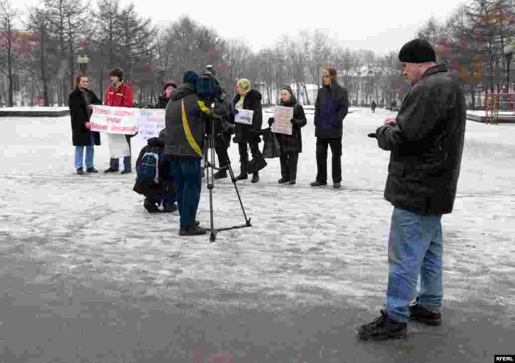 Некто в штатском переписывает тект лозунгов в блокнот