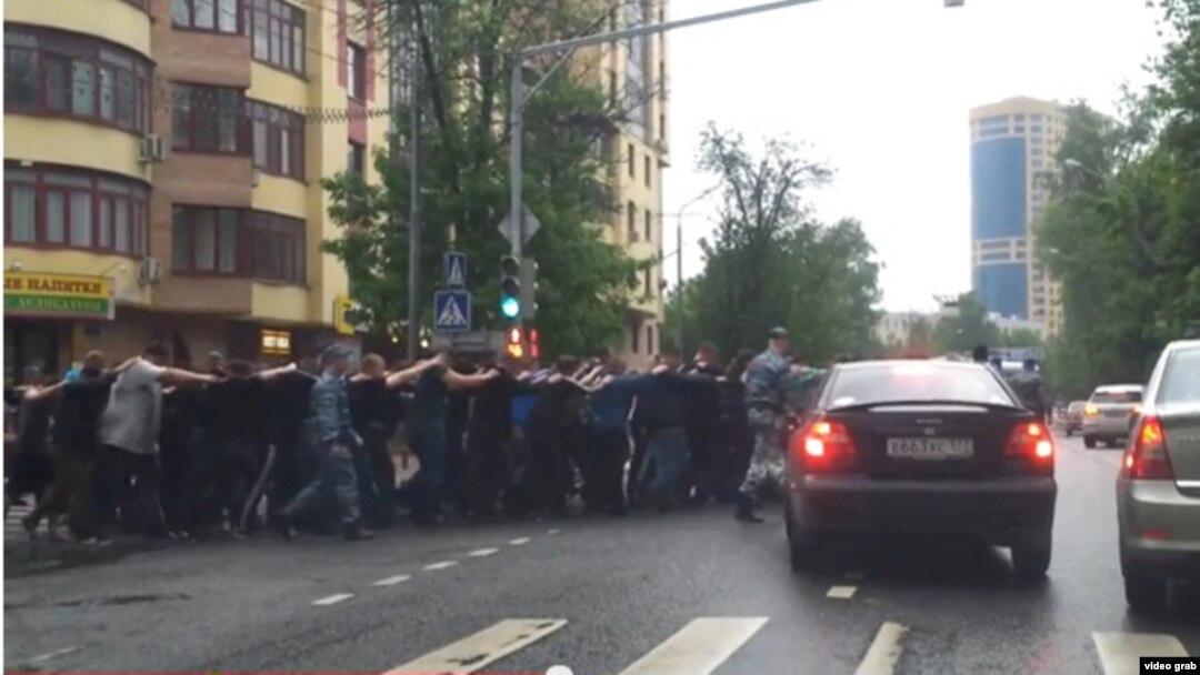Russia - russian police officers are taking migrants to police station in the street