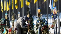 Женщина на могиле погибшего сына на каладбище в городе Ирпень (Киевская область)